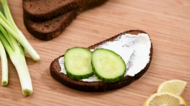 Tütsülenmiş somon tostuyla hareketli animasyonu durdurun. Sağlıklı tost çavdar ekmeği, salatalık, krem peynir ve bir dilim füme somon.