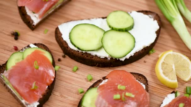 Gerookte Zalm Roggebrood Toast Met Roomkaas Komkommer Houten Snijplank Van — Stockvideo