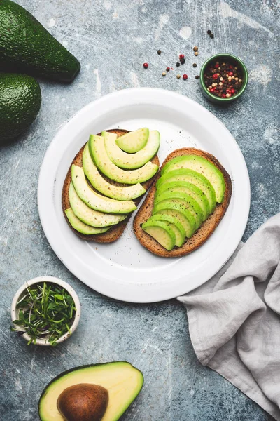 Веганский авокадо и тост с ржаным хлебом на тарелке — стоковое фото
