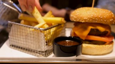 Kadın eli, patates kızartmasını domates sosuna batırır. Sadece Yemek Lokantası, Sağlıksız Yeme Konsepti