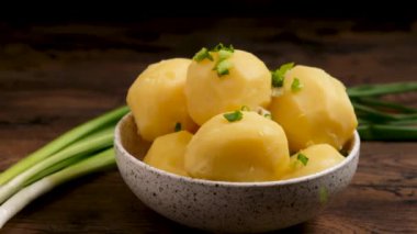 Haşlanmış patates ve taze soğan. Haşlanmış altın patatesin üzerine düşen doğranmış taze soğanın yavaş hareketi.