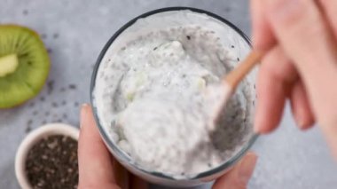 Tahta kaşıkla Chia Pudding yemek. Sağlıklı Vejetaryen Diyet Konsepti. Temiz yemek, kilo kaybı.