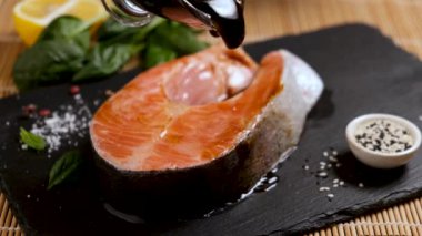 Teriyaki soslu balık somon bifteği pişirmek. Çiğ balık bifteğine sos ekliyorum. 4k çözünürlük.