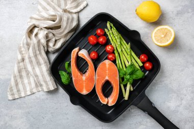 Somon bifteği, kuşkonmaz ve sebzeler ızgarada.