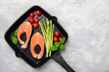 Izgarada pişmemiş somon bifteği ve sebze.