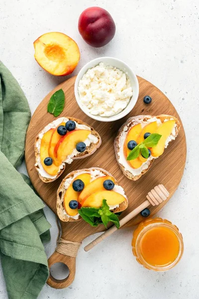 Sweet Bruschetta With Ricotta Cheese, Peach, Blueberries and Honey — стокове фото