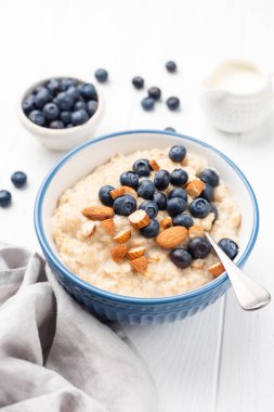 Bowl of porridge oats with blueberries, almonds clipart