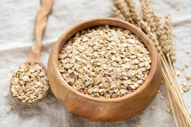 Oat flakes, rolled oats in wooden bowl