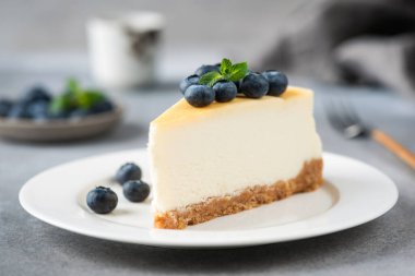 Cheesecake slice with blueberries on white plate