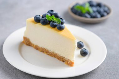 Slice of plain cheesecake topped with fresh blueberries