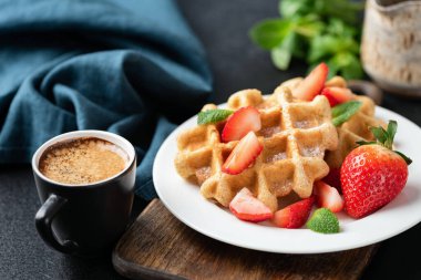Çilekli Belçika Waffle 'ı ve bir fincan kahve.