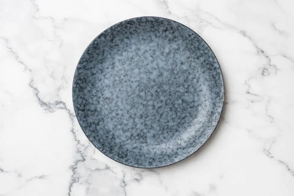 Assiette bleue sur fond de marbre blanc — Photo