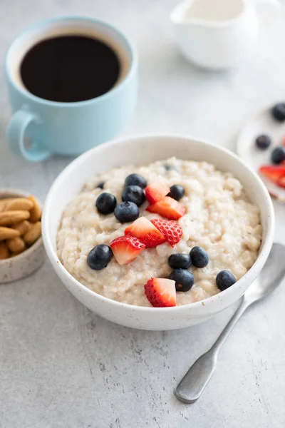 Oatmeal porridge with berries and cup of coffee
