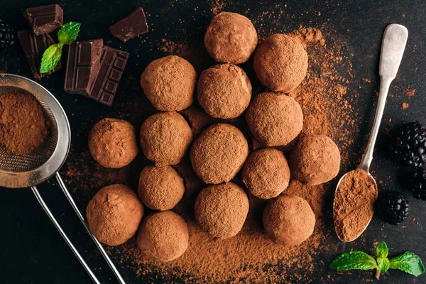 Chocolade truffels op zwarte leisteen achtergrond — Stockfoto