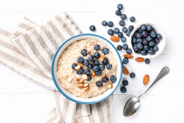 Oatmeal porridge with blueberries, almond nuts, top view — Stock Photo, Image