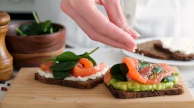 Avokado somon ve tohumlu sağlıklı çavdar ekmeği tostu. Aşçının Yavaş Hareketi kenevir tohumlu garnitür yiyeceği. Omega 3 'te Zengin Yağlı Aslar Yemeği