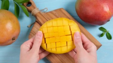 Taze olgun mango yarım küp şeklinde, masa üstü manzaralı. Vejetaryen yemekleri, tropikal meyveler.