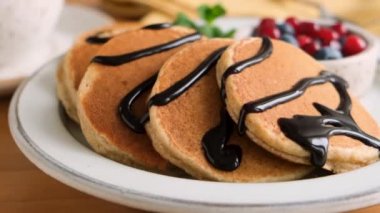 Çikolata soslu kahvaltı krepleri ve tabakta yaz meyveleri, yakın çekim slayt görüntüsü.