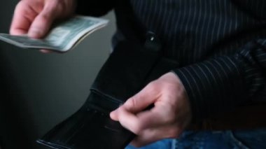 İş adamı cüzdanında dolar sayıyor. Erkek ellerine yakından bakmak dolarları sayar. Az para, iflas konsepti, ekonomik kriz