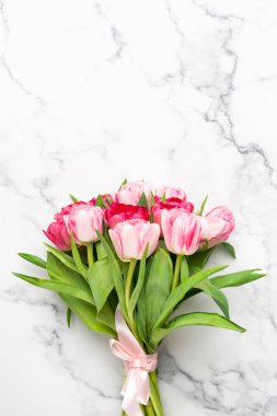 Mermer arka planda pembe laleler.