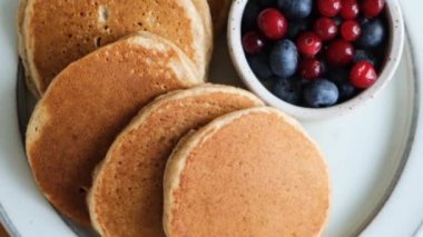 Muzlu krep ve tabakta böğürtlen. Kahvaltının en tepesindeki gözlemeler ahşap masada.