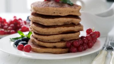 Bir yığın karabuğday krepi ve taze yaz meyveleri yakın çekim görüntüsü.