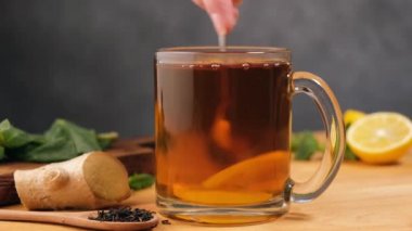 Bir fincan zencefilli limon çayı. Kaşıkla çay karıştırmak