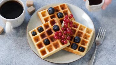 Belçika wafflelarının üzerine akçaağaç şurubu döküyorum. Böğürtlen ve akçaağaç şurubuyla servis edilen tatlı Belçika waffle 'ları.