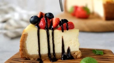 Çatalla cheesecake 'ten bir ısırık almak. Cheesecake yemek.