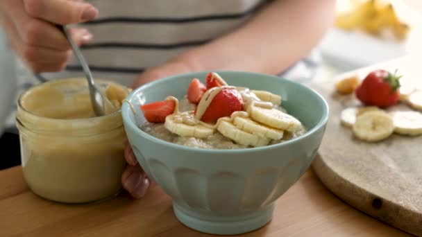 Mingau Aveia Com Manteiga Banana Morango Nozes Adicionando Manteiga Noz — Vídeo de Stock