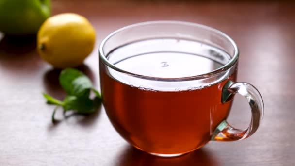 在木制桌子上的玻璃杯中煮着一杯红茶 热红茶 — 图库视频影像