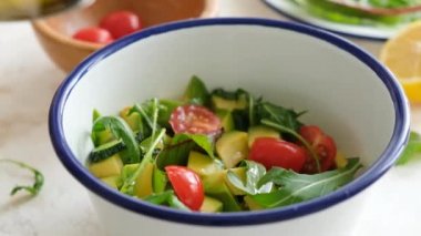 Avokado, domates ve salatalık salatasına zeytin yağı ekliyorum. Yakından bak. Diyet yemek.