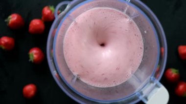 Siyah arka planda blender ile karıştırılmış pembe dutlu smoothie, üst manzara. Sağlıklı vejetaryen içeceği
