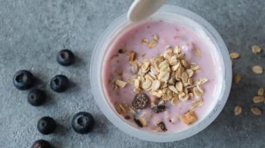 Plastik kavanozda yabanmersinli yoğurt ve müsli. Sağlıklı kahvaltı ya da atıştırmalık yemek. Mağaza müsli ve taze yaban mersinli yoğurt aldı.