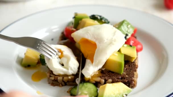 Comer Tostadas Aguacate Huevo Escalfado Con Tenedor Cuchillo Cortar Huevo — Vídeos de Stock