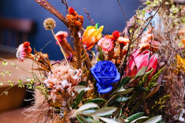 Çok renkli bir gülün ortasında kurumuş mor güller..