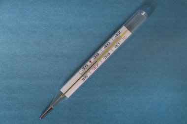 Tıbbi bir civa termometresi yüksek ateş olduğunu gösteriyor. Hastalık ve tedavi.