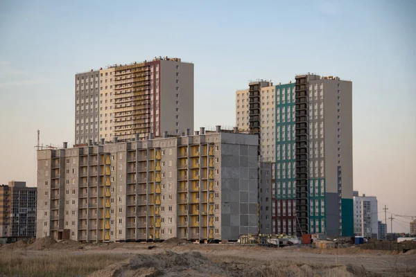 Multi-storey residential buildings of the new district are being built on the banks of the river. New housing for residents.