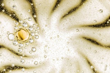 Ein Glas mit Wasser und mit kleine Olivenl tropfen.