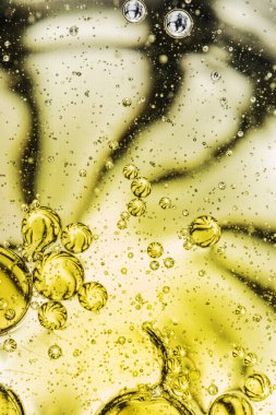 Ein Glas mit Wasser und mit kleine Olivenl tropfen.