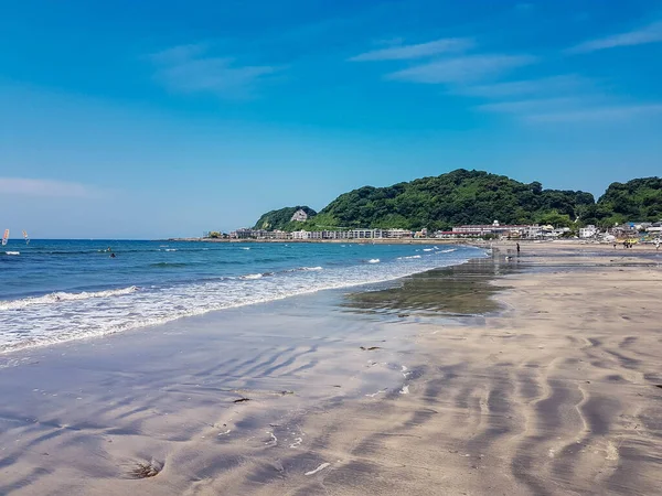 Kamakura的海滩几乎是空的 早上沙滩上有浪花 蓝天上有浪花 图库图片