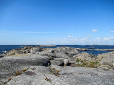 Mavi gökyüzü ve deniz ile Rocky Adası manzarası.
