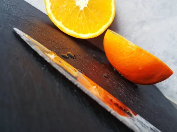 Zusammensetzung Einer Geschnittenen Orange Und Eines Messers Auf Einem Schwarzen — Stockfoto