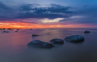 Deniz cliff üzerinde ateşli günbatımı