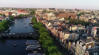Hollanda, Amsterdam 'daki ünlü yerlerin hava manzarası, bahar veya yaz günbatımında. Kanal ve eski merkez bölgenin yukarısına bak. Arka planda Munttoren Çan Kulesi var. Hollanda 'da ünlü yerler