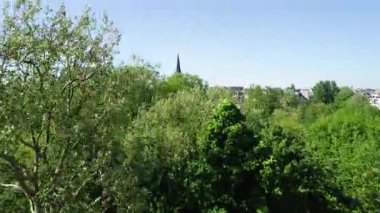 Hollanda 'nın Amsterdam şehrindeki Vondelpark' ın 4k hava görüntüsü. Güneşli bir gün, yaz ya da bahar. İnsanlar gölün etrafındaki yeşil çimlerde dinleniyorlar. Konsept: Hollanda 'da ünlü yerler.