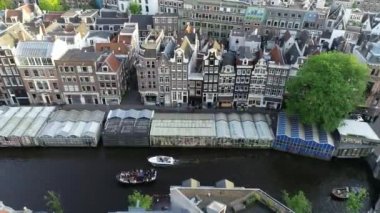 Amsterdam, Hollanda 4K 'da. Kanal ve eski merkez bölge üzerindeki hava manzarası. Ünlü Amsterdam kanalları, parti tekneleri ve tipik Hollandalı evleri. Şehrin güzel, sıcacık renkleri.