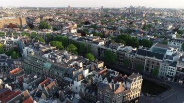 Hollanda 'daki Amsterdam' ın panoramik hava manzarası 4K 'da. Kanal ve eski merkez bölgenin yukarısına bak. Arka planda Munttoren Çan Kulesi var. Amsterdam 'da güzel sıcak renklerde ünlü yerler