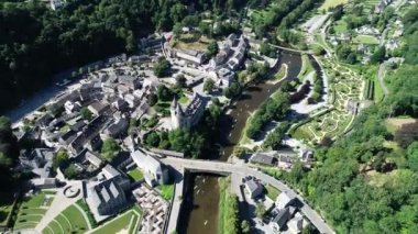 Belçika 'nın Durbuy kentindeki eski kasaba ve kalenin havadan görünüşü, yaz mevsiminde nehirdeki dağlar, nehirler ve kayakçılarla çevrili. Şehrin Panoraması