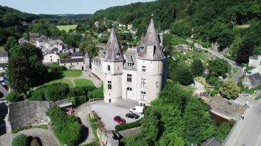Belçika 'nın Durbuy kentindeki eski kasaba ve kalenin havadan görünüşü, yaz mevsiminde nehirdeki dağlar, nehirler ve kayakçılarla çevrili. Şehrin Panoraması